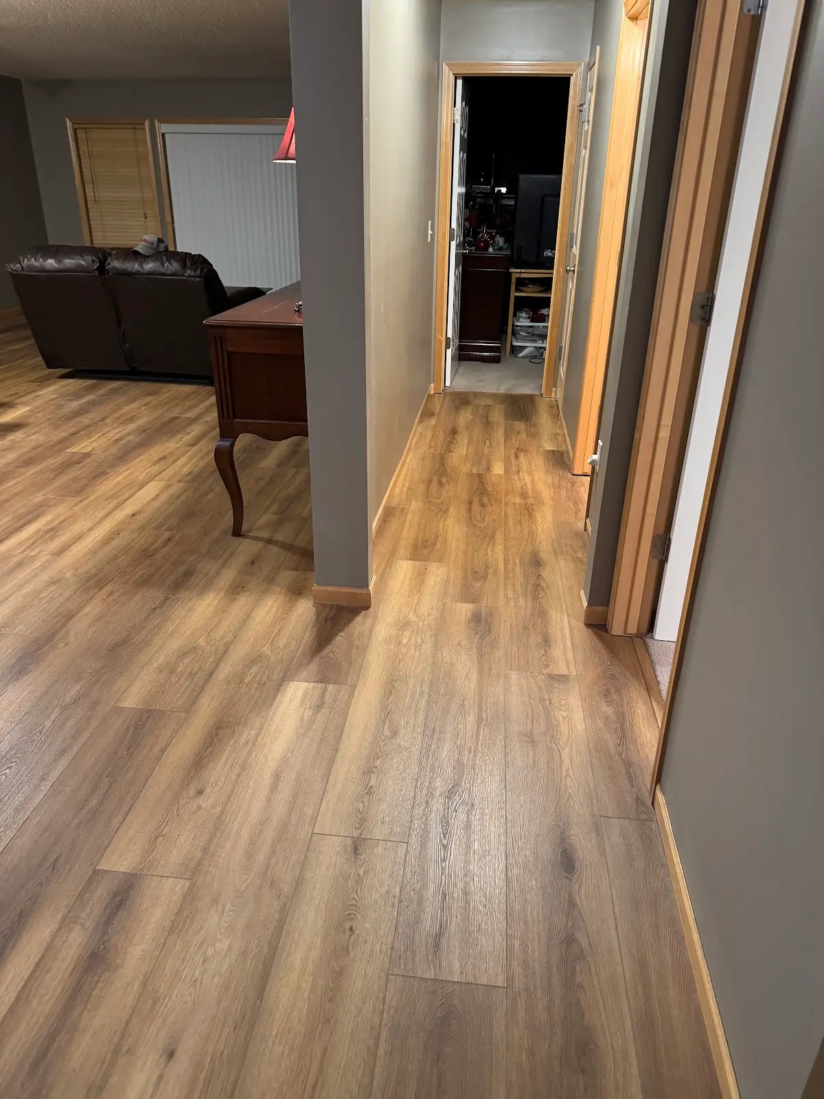 Warm oak luxury vinyl plank flowing through a family room and hallway